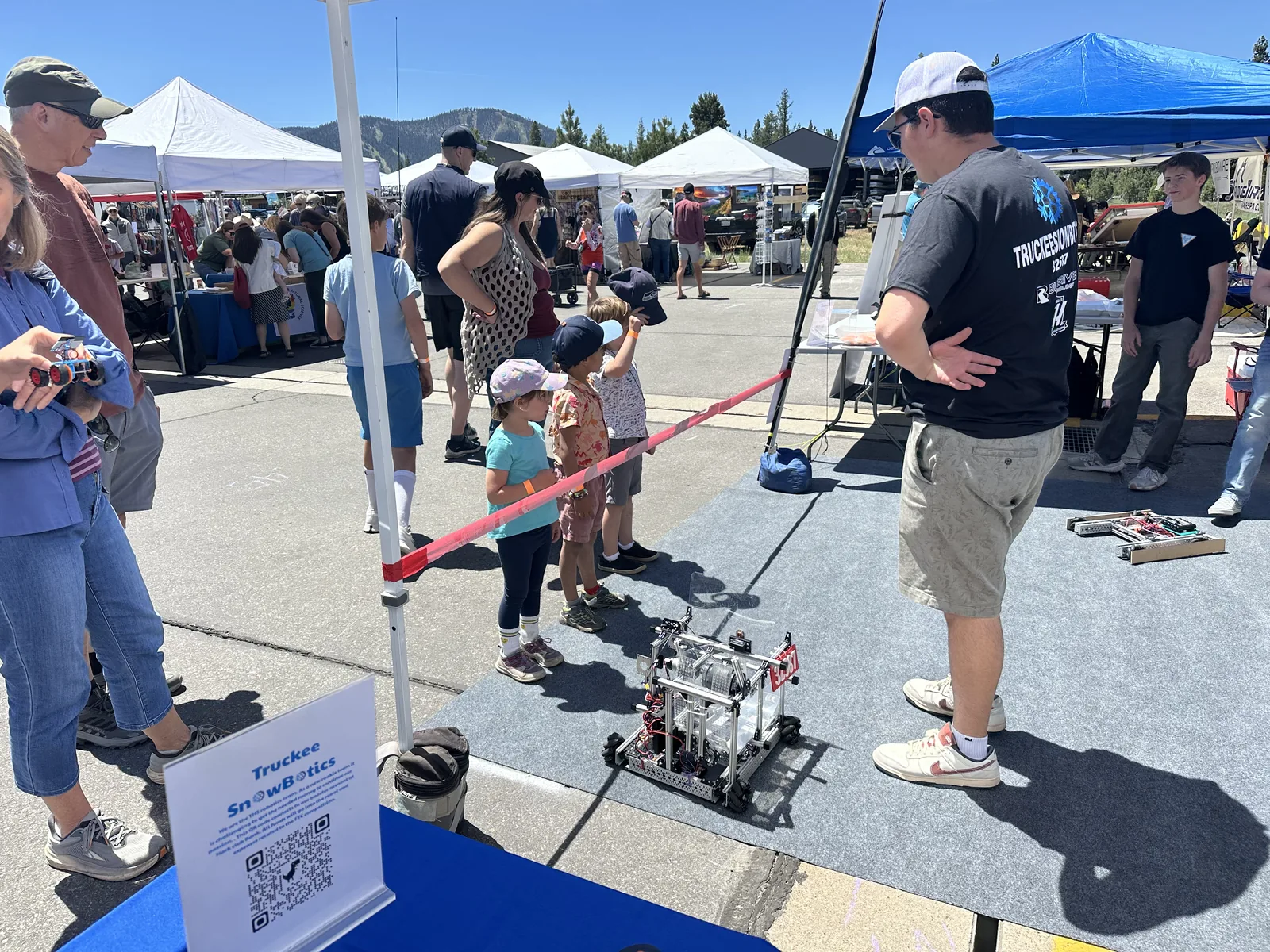 Kids watching a Snowbotics robot demonstration at a community show