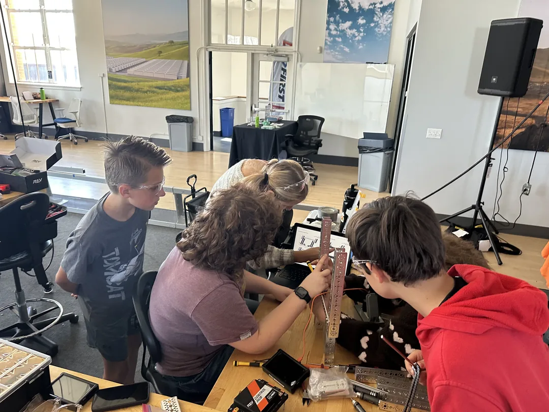 Students and mentors working on a robot together at a build session