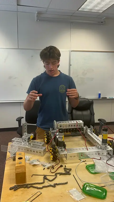 A team member assembling robot parts at the workbench.