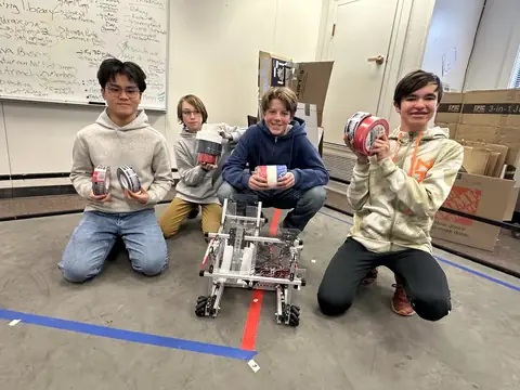 Team members with the robot on our practice field, marked out with tape.